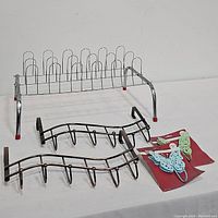 Photo showing all items in the lot on a white surface, including the shoe rack, two over the door hanging racks, and two butterfly wall hooks still on display cards.