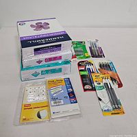 Complete lot showing three packages of Hammermill paper, file folder labels from Avery, Staples reinforcements, multiple packs of pens, and mechanical pencil lead.