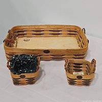 Photo showing all three Peterboro baskets including large serving tray, green trimmed basket with fabric liner, and small basket.
