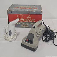 Lot contents with Kirby Sentra carpet shampoo system, vintage Hoover brush vac, and multi-use handheld wrinkle remover with original Kirby box.