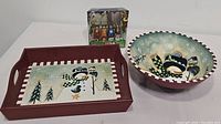 Photo showing rectangular tray, large round bowl, and pack of spreaders with holiday designs, all snowman themed