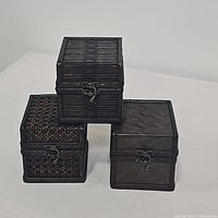 Three dark-woven small vintage boxes stacked and arranged to show variation in patterns and sizes.