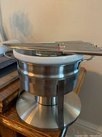 Stainless steel base with ceramic fondue pot and fondue forks resting on top