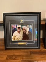 Full view of framed photo showing Jack Nicklaus and Arnold Palmer, Masters pin and name plaque.