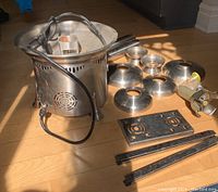 Photo of all disassembled parts of the Sephra chocolate fountain including base with motor, stainless steel bowls, rods, motor housing, metal base plate and brackets, power cord.