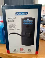 Front of box showing Schlage Keypad Lever lock with keypad and lever handle.
