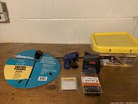 Photo of the lot items arranged showing Gilmour faucet extender packaging, Bosch tool, clamp, screws container, and pack of nails.