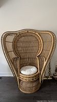 Front view of wicker armchair with round white cushion