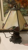 Side perspective of the Tiffany style stained glass and brass table lamp showing the shade coloration and ornate base