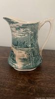 Emily Meakin Tintern porcelain pitcher showing riverside cottage and trees in green transfer design on white base.