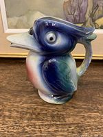 Porcelain pelican-shaped teapot, front and right side view showing detailed paint and glaze.