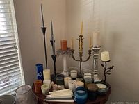Full assortment on table showing various candles and candle holders