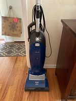 Front view of dark blue upright vacuum showing overall condition and body shape