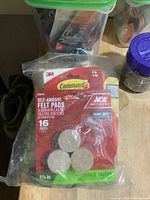 Close-up of 3M Command and Ace Heavy Duty Self-Adhesive Felt Pads, with packaging visible showing quantity and size.