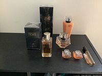 Photo of three boxed and unboxed Lancôme perfume bottles, peach colored bath gel, three mini perfume bottles, and one mini roller ball perfume.