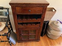Front view of solid wood wine cabinet showing drawer, wine racks, and lower cabinet with glass door.