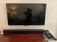 Sony 47-inch LCD TV mounted above wooden surface with Sony sound bar below it visible.
