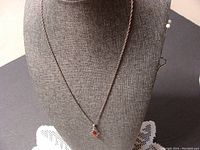 Full view of the amber pendant on the silver chain displayed on a necklace bust showing chain length and pendant size.