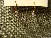 Front view showing matching oval aquamarine stones in gold settings on leverback hooks.