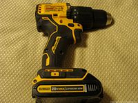 Side view of DeWalt cordless hammer drill with attached 20V Max lithium-ion battery, showing yellow and black design, grip, and control details.