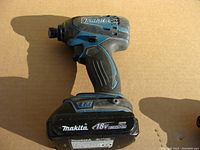 Side view of Makita cordless impact driver showing model and lithium-ion battery pack.
