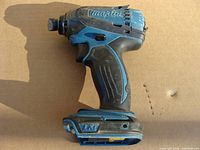 Side-angle photo showing Makita impact driver with some wear, no battery attached.