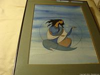 Framed art print depicting a Native styled figure with flowing hair against a blue sky.