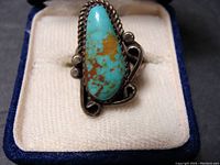 Front view of the sterling silver ring with turquoise stone, showing the blue and brown matrix in the elongated stone and surrounding silver detailing.