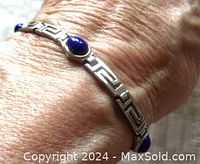 Bracelet worn on wrist highlighting lapis lazuli gemstones and silver links.