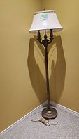 Full view of the metal standing floor lamp with fabric lampshade showing height and overall design.