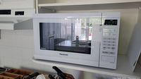 Front and right side view of a white Panasonic microwave oven model NN-ST632W on a kitchen countertop.