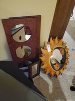 Group photo of the four mirrors, showing the sun-themed celestial mirror prominently, alongside the rectangular panel mirror with two circular mirrors and a smaller framed mirror.