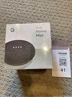 Front view of the sealed Google Home Mini box showing the device image and branding.