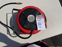 Top-down view of RedWorks mini hose reel compressor hose showing round reel body and hose coiled inside.