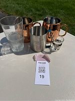 Image showing the five drinking glasses, including Jameson tall glass, two copper mugs, one silver Absolut mug, and Zagat shot glass.