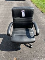 Front view of black leatherette executive office chair showing padded armrests and stitched seat and backrest.