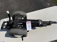 Folded Spalding golf pull cart from side angle showing wheels and handle