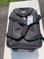 Top view of black High Sierra travel duffle with shoulder straps and top handle visible.