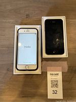 Both iPhones displayed in their boxes; iPhone 6 shows 'Hello' screen, iPhone 4 is black with screen off, set next to phone 6 box.