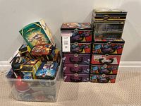 Overall view of Pokemon and hockey tins including lunch boxes and a plastic bin with assorted tins and dice