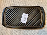 Top view of the Paderno double-sided cast iron skillet showing the ridged grill surface with handles at each side and a MaxSold lot number card.