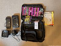 Top-down view of all items laid out including carrying case, game manuals, battery pack, magnifier, and charging cable.