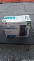 Box of APC Battery Backup system showing front with power capacity and price savings.