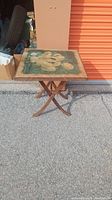 Antique folding card table showing painted floral top and structure.