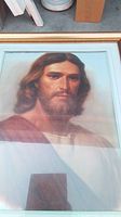 Close-up photo of the framed print showing Jesus' face and upper torso.