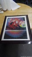 Framed Spiderman art print showing the entire artwork with dark frame, placed on a table.