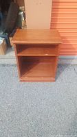 Front view of the vintage pine shelf or stand on concrete ground outside a storage unit.