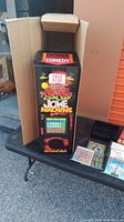 Vertical arcade-style Yuk Yuk joke machine in box with colorful comic text and graphics on the front