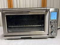 Full front view of the stainless steel toaster oven showing the door, handle, and control panel.