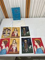 Photo of the Christmas card collection cards and blue storage box on white sheet.